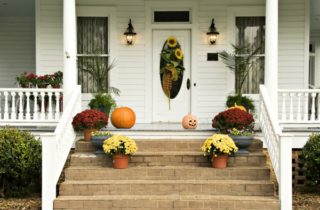 front porch of home decorated for fall