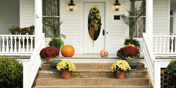 front porch of home decorated for fall