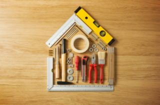 home construction concept with tools in shape of house