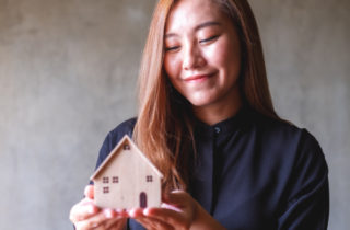 Woman holding small house