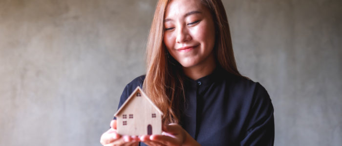 Woman holding small house
