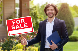Male realtor holding For Sale sign