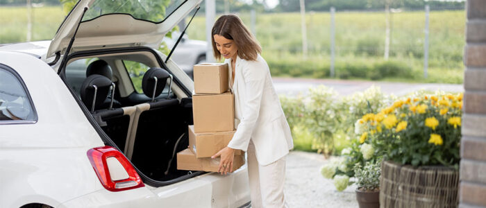 woman getting boxes out of the back of a car