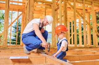 Man with boy and drill in new construction