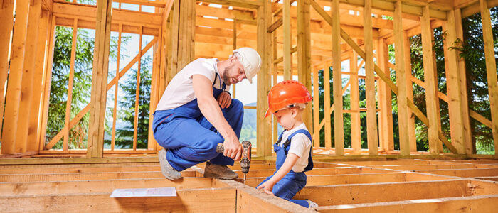 Man with boy and drill in new construction