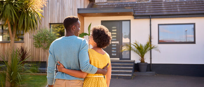 man and woman standing in front of a house