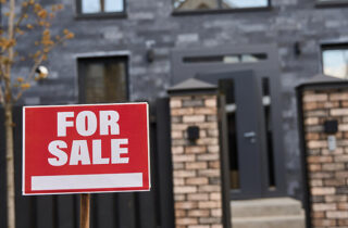 For sale sign in front of house