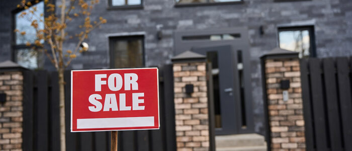 For sale sign in front of house