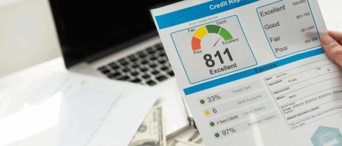 cropped view of man holding paper with credit report letters near laptop with blank screen