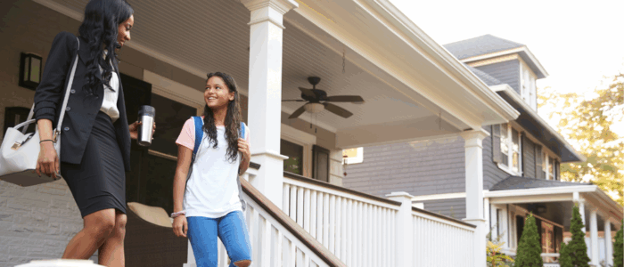 Businesswoman Mother Walking Daughter To School On Way To Work
