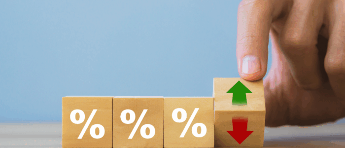 Hand holding wooden block with arrow and percentage symbol