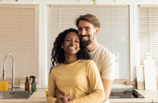 heterosexual couple smiling hugging