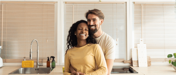 heterosexual couple smiling hugging