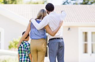 Parents And Son Standing In Garden