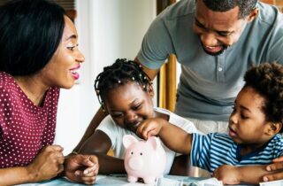 Family putting money in piggy bank