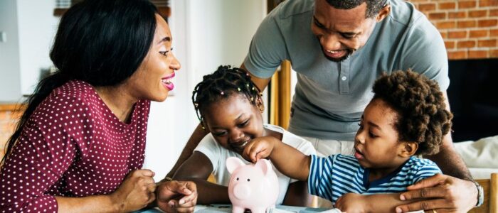 Family putting money in piggy bank