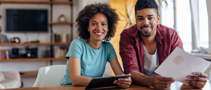 Adult couple, posing for the picture, at home office.