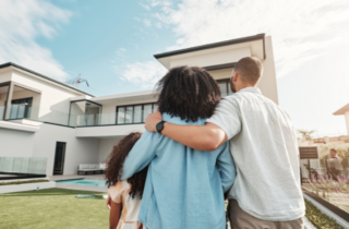 Family Embracing Outside of Modern Home on Sunny Day