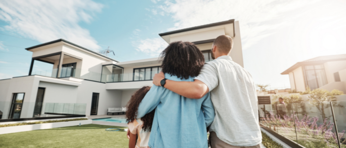 Family Embracing Outside of Modern Home on Sunny Day